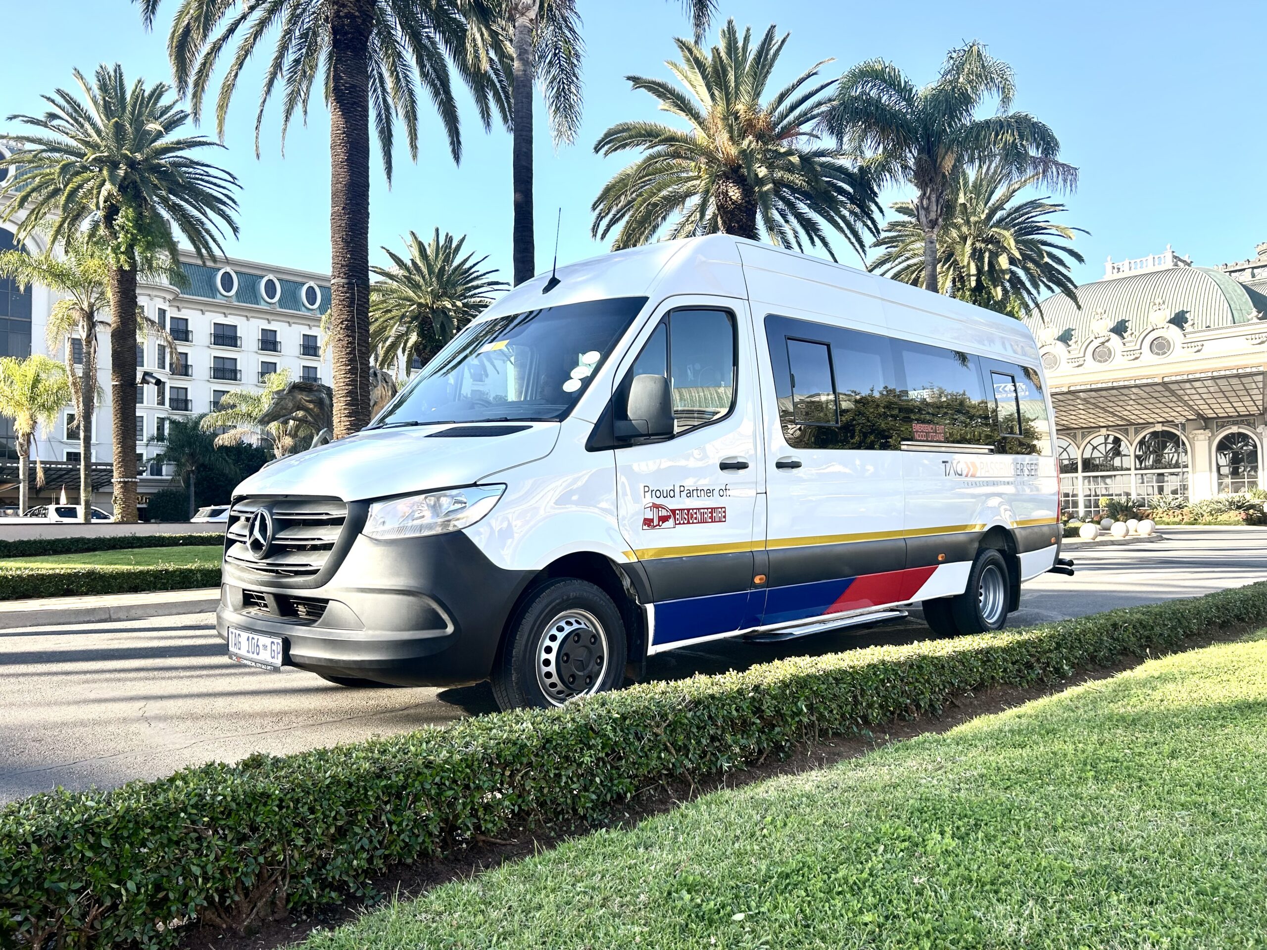 22-seater bus available for hire in Johannesburg from Bus Hire Johannesburg, powered by TAG Passenger Services – ideal for group travel, school transport, and events. Branded with TAG Passenger Services and proudly partnered with Bus Centre Hire standing outside Emperors Palace in Kempton Park