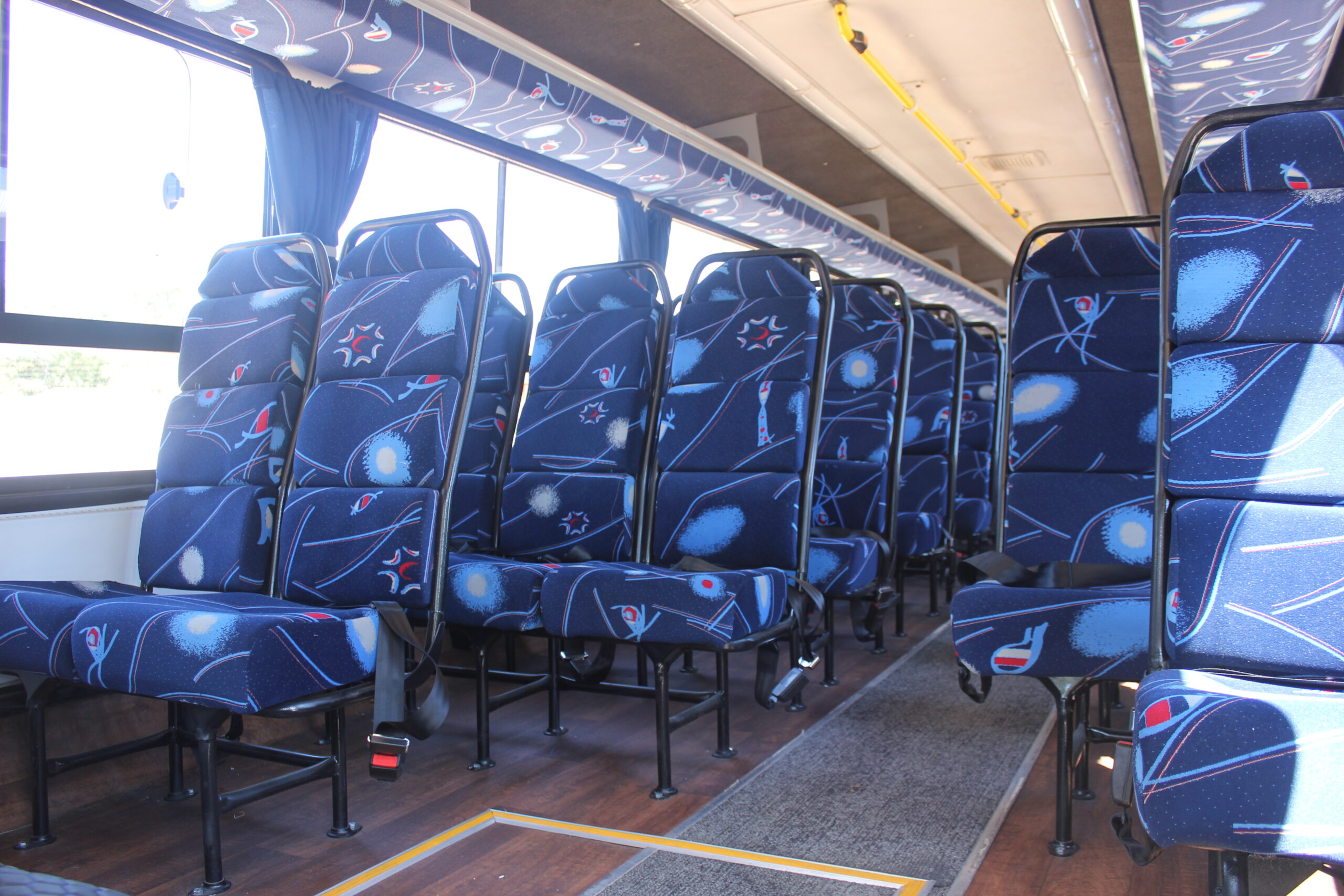Spacious interior of our 60-seater bus available for bus hire in Johannesburg, featuring comfortable cloth seats, parcel shelves, and safety belts – perfect for school trips, events, and private group transport | TAG Passenger Services