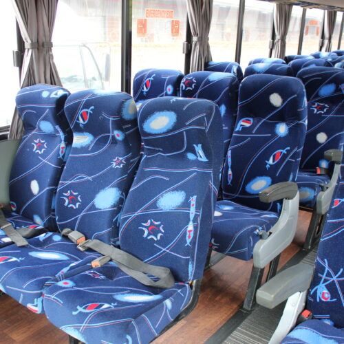 Spacious interior of our 71-seater bus available for bus hire in Johannesburg, featuring comfortable cloth seats, parcel shelves, and safety belts – perfect for school trips, events, and private group transport | TAG Passenger Services