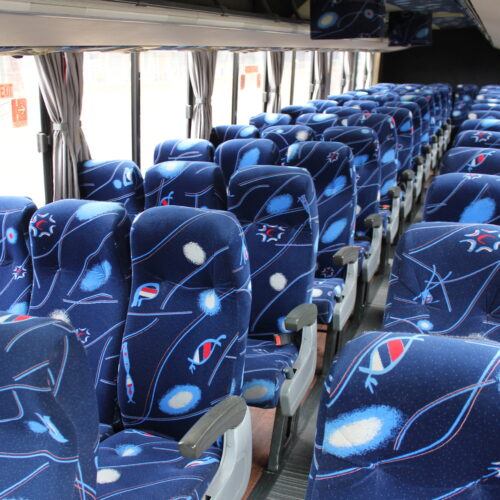 Spacious interior of our 71-seater bus available for bus hire in Johannesburg, featuring comfortable cloth seats, parcel shelves, and safety belts – perfect for school trips, events, and private group transport | TAG Passenger Services