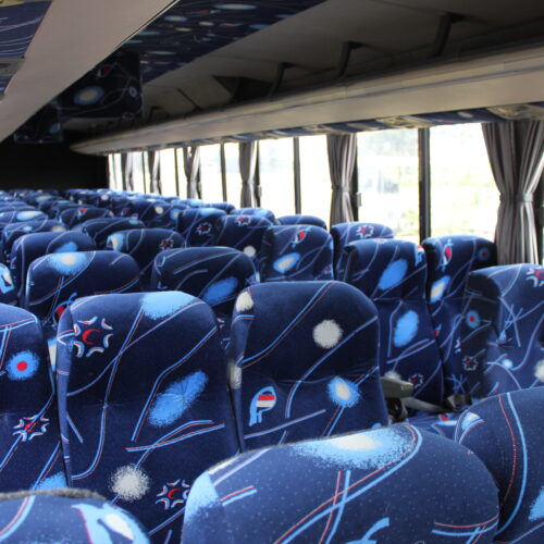 Spacious interior of our 71-seater bus available for bus hire in Johannesburg, featuring comfortable cloth seats, parcel shelves, and safety belts – perfect for school trips, events, and private group transport | TAG Passenger Services
