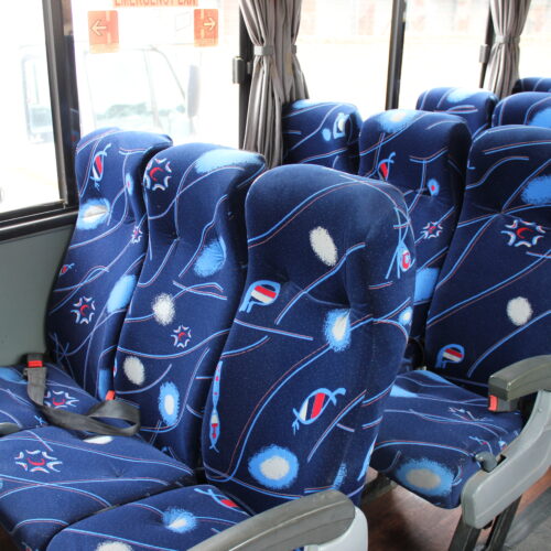 Spacious interior of our 71-seater bus available for bus hire in Johannesburg, featuring comfortable cloth seats, parcel shelves, and safety belts – perfect for school trips, events, and private group transport | TAG Passenger Services