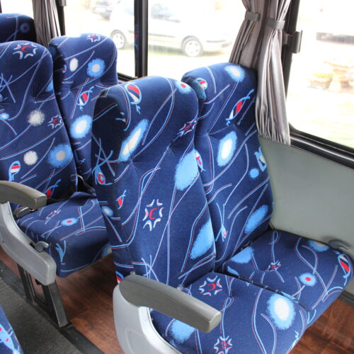 Spacious interior of our 71-seater bus available for bus hire in Johannesburg, featuring comfortable cloth seats, parcel shelves, and safety belts – perfect for school trips, events, and private group transport | TAG Passenger Services
