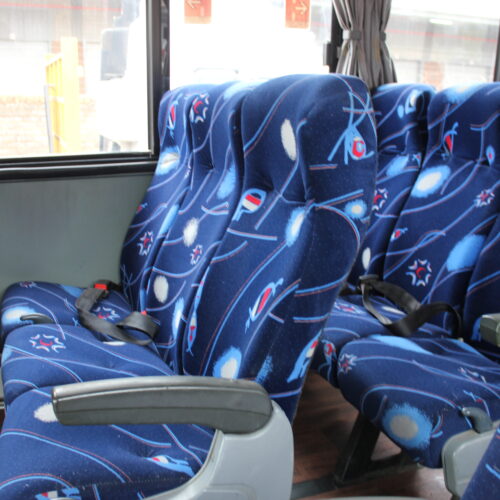 Spacious interior of our 71-seater bus available for bus hire in Johannesburg, featuring comfortable cloth seats, parcel shelves, and safety belts – perfect for school trips, events, and private group transport | TAG Passenger Services
