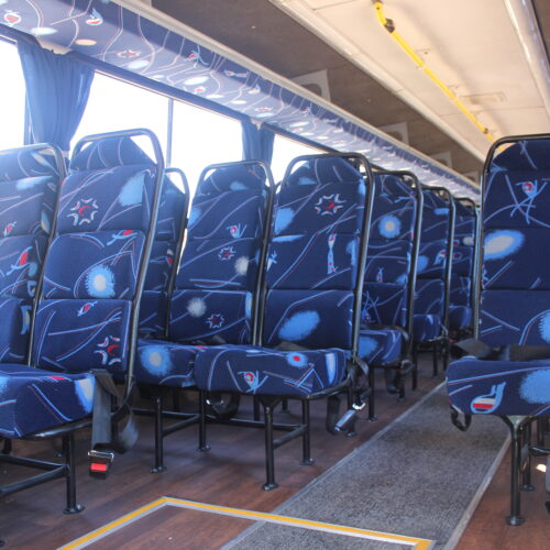 Spacious interior of our 60-seater bus available for bus hire in Johannesburg, featuring comfortable cloth seats, parcel shelves, and safety belts – perfect for school trips, events, and private group transport | TAG Passenger Services